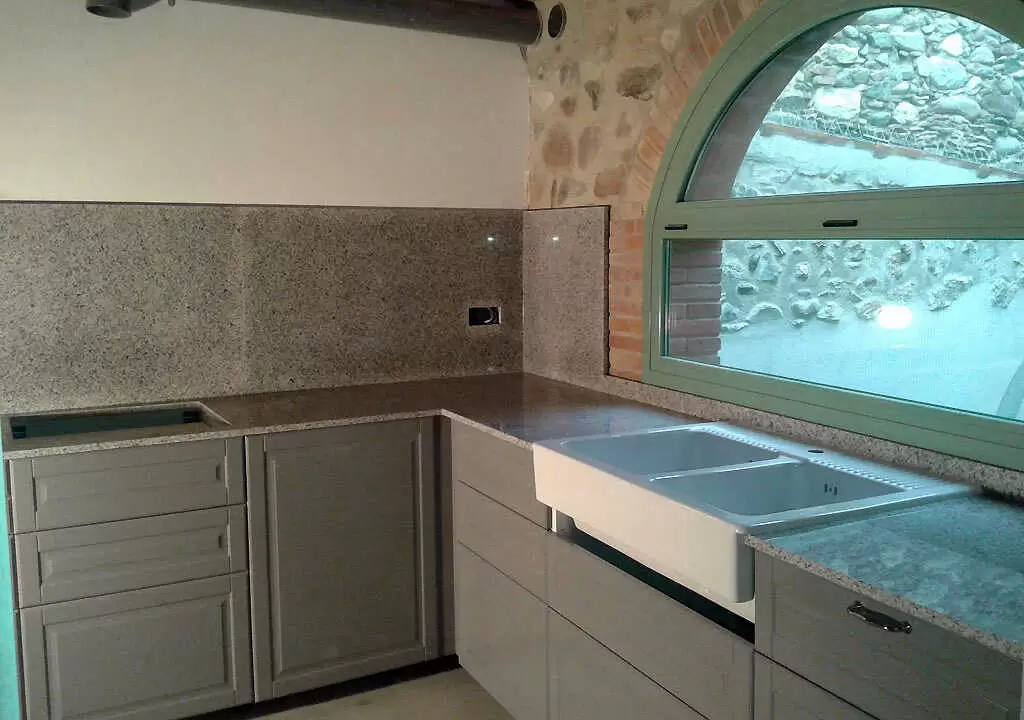 Encimera de granito Blanco Cristal con revestimiento de pared
