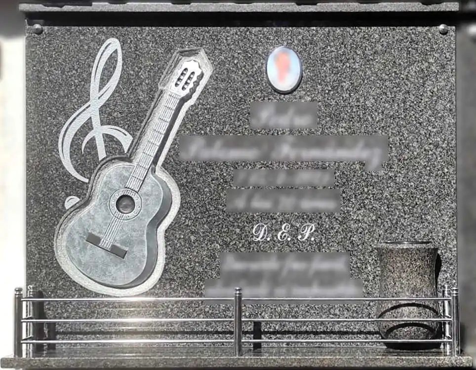 Lápida con guitarra tallada